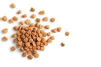 Scattered brown butterscotch baking chips on white background, isolated food ingredients for desserts and confectionery. Top view with copy space.