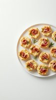 Elegant prosciutto and rosemary appetizers in golden pastry cups arranged on white plate for gourmet entertaining and holiday party catering.
