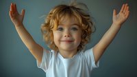 Joyful Caucasian child with curly blonde hair and blue eyes raising arms up in white t-shirt against blue background, expressing happiness and victory.