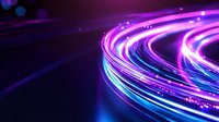 Glowing curved light trails in neon purple and blue colors against dark background create dynamic motion effect with bright streaks and sparkles.