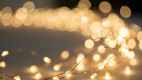 Warm golden bokeh lights creating magical atmosphere with soft glowing orbs and delicate string lights for festive holiday decorations and cozy ambiance.