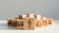 Wooden blocks with business people icons representing human resources management and team building concepts for corporate training materials.