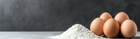 Fresh brown eggs and white flour on marble counter against dark background for baking and cooking recipes.