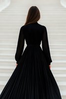Young woman in elegant black pleated maxi dress with long sleeves shown from behind against white background, fashion and formal wear concept.