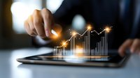Businessman analyzing glowing financial chart on digital tablet, showcasing market growth and data visualization for investment strategy planning.