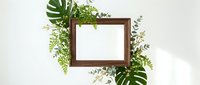 Wooden frame surrounded by lush green foliage and tropical leaves on white background, suitable for nature-themed designs, botanical presentations, and eco-friendly branding projects.