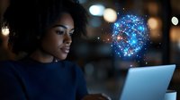 Young African American businesswoman working on laptop with glowing digital brain hologram representing artificial intelligence and machine learning technology.