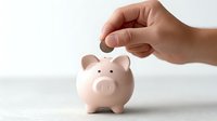 Hand dropping coin into pink piggy bank on white background representing savings, financial planning and money management concepts for investment goals.