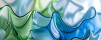 Smooth flowing waves in blue and green gradient colors create abstract background pattern with soft glossy curves and undulating shapes for modern design.