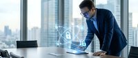 Male professional in business attire examining holographic security interface at modern office desk with city skyline, representing cybersecurity, data protection, and digital technology solutions.