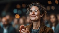 Middle-aged Caucasian woman with tousled hair smiling joyfully at corporate event with warm bokeh lights and blurred crowd background for business presentations.