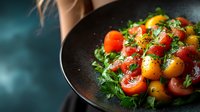 Fresh colorful cherry tomatoes with herbs and seasoning on dark plate against moody background, selective focus on juicy vegetables for food photography.