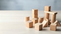 Wooden building blocks scattered on light surface creating abstract geometric composition for creative play and educational development concepts.