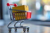 Shopping cart with yellow packages for online retail and e-commerce delivery services on blurred background.