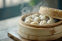 Steaming hot dumplings in traditional bamboo steamer basket with rising vapor, soft natural lighting creates cozy atmosphere for Asian cuisine presentation.