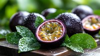 Fresh passion fruits with water drops and green leaves on dark wooden surface, whole and cut in half showing juicy pulp and seeds. Food photography.
