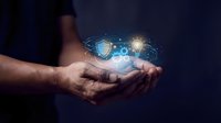 Businessman hands holding glowing digital security shield and lightbulb icons representing cybersecurity protection and innovative technology solutions.