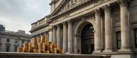 Stack of gold coins in front of a grand neoclassical bank building, symbolizing wealth, financial power, and economic stability.