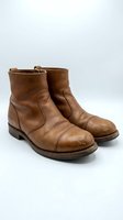 Vintage brown leather ankle boots with worn patina isolated on white background for fashion and footwear design projects.