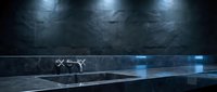 Futuristic drone with glowing blue lights hovers above sleek platform in dark industrial warehouse setting with dramatic overhead lighting and reflective surfaces.