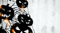 Halloween pumpkin jack-o-lantern silhouettes with spider web shadows cast on textured concrete wall background for spooky seasonal decoration design.