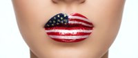 Close-up of woman's lips painted with stars and stripes flag pattern for patriotic makeup, beauty and national pride celebration concepts.