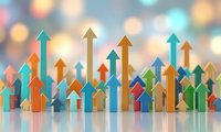 Colorful wooden arrow blocks pointing upward on reflective surface with bokeh lights background representing business growth and success concepts.