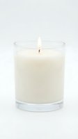 Lit white soy candle in a clear glass jar isolated on white background, perfect for home decor, spa, and wellness product photography.