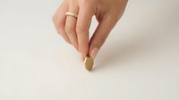 Woman hand holding golden coin on white background for financial investment and savings concept.