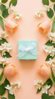 Mint gift box with white bow surrounded by peach tulips and jasmine flowers on pastel background, flat lay for spring holiday greeting.