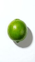 Fresh green lime with water droplets isolated on white background, suitable for food and beverage design projects.