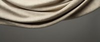 Elegant beige silk fabric with soft flowing curves and luxurious texture creating smooth waves against neutral background for premium design projects.