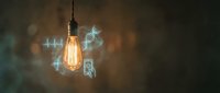 Vintage Edison bulb glowing with digital holographic icons floating around representing modern technology and innovation concepts for business presentations.