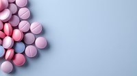 Pink and purple pharmaceutical pills scattered on gray background, creating minimalist medical composition with copy space for healthcare messaging.