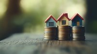 Small wooden houses placed on stacks of coins against blurred natural background, representing real estate investment, property market and financial growth.
