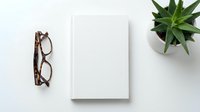 Minimalist workspace with blank white notebook, tortoiseshell glasses and green succulent plant on clean white desk surface for business branding mockup.