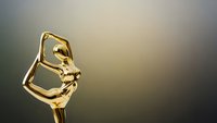 Golden trophy award statue with elegant curved design on gradient background for recognition ceremonies and achievement celebrations.