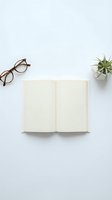 Open blank notebook with eyeglasses and succulent plant on white background for workspace design and planning concepts.