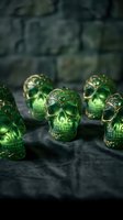 Green ornamental skull figurines with golden filigree details arranged on dark fabric against stone backdrop. Perfect for gothic, Halloween, and alternative design projects.