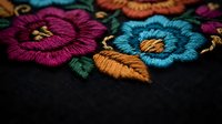 Vibrant embroidered flowers with colorful thread work on dark fabric showcasing traditional needlework craftsmanship and decorative textile art techniques.