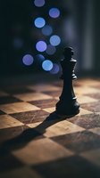 Black chess king piece standing on wooden chessboard with blue bokeh lights in background creating strategic business concept for leadership and decision making.