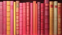 Row of vintage hardcover books in warm colors - pink, yellow, orange, and red - arranged on bookshelf, creating vibrant library display.
