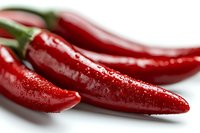 Fresh red chili peppers with water drops on white background, macro shot showing glossy surface and vibrant color. Suitable for food and cooking concepts.