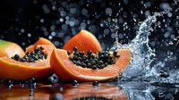 Fresh papaya slices with black seeds splashing in water against dark background. Tropical fruit nutrition concept for healthy eating and diet content.