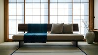 Modern minimalist sofa with navy blue throw and olive cushions positioned against large gridded window in contemporary living room interior design space.