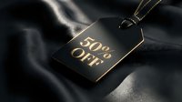 Luxury black and gold price tag with 50% off text on dark silk fabric, evoking premium fashion sale and exclusive discount concept.