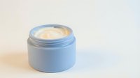 Open blue cosmetic jar with cream or moisturizer inside, isolated on white background for skincare product packaging, beauty branding, and cosmetics design use.
