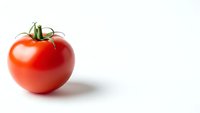 Fresh red tomato with green stem isolated on white background for healthy cooking and nutrition concepts.