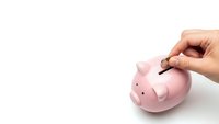 Hand inserting coin into pink piggy bank on white background for savings and financial planning concepts.