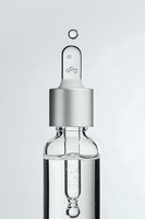 Glass dropper bottle with clear liquid and silver cap against white background, showing bubble formation in minimalist composition.
